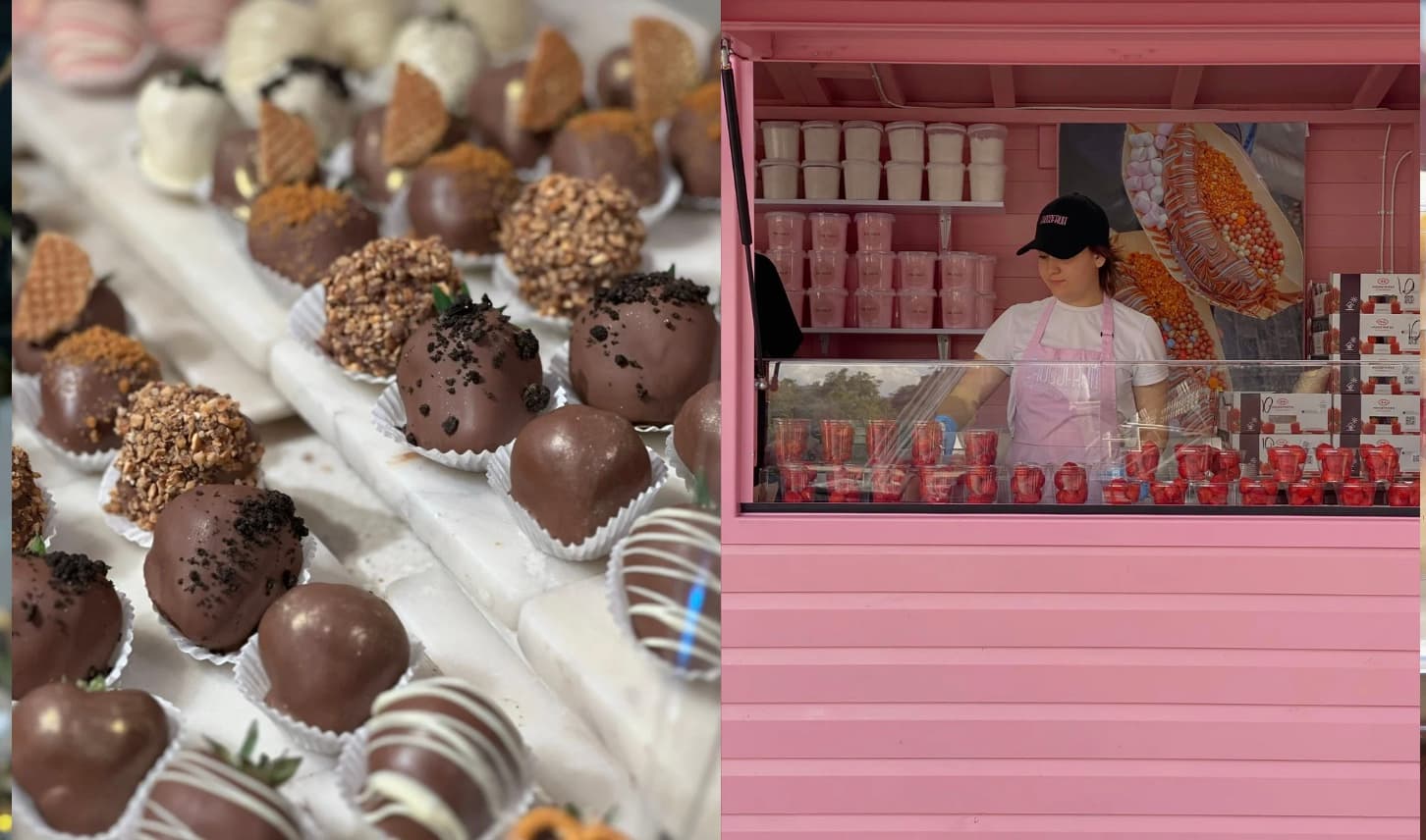 Assorted chocolate-covered strawberries next to a woman working in a bright pink dessert stall.
